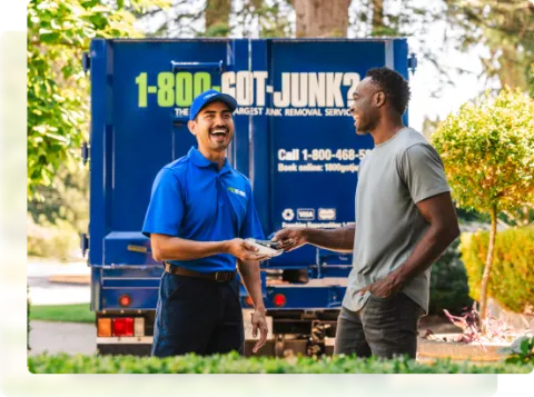 1-800-GOT-JUNK junk removal expert getting payment from happy customer outside