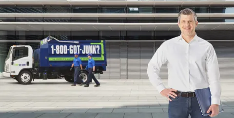 happy property manager in front of team members removing junk